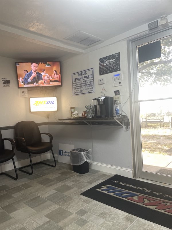 Customer waiting room at Ideal Service Center with TV, coffee and seating