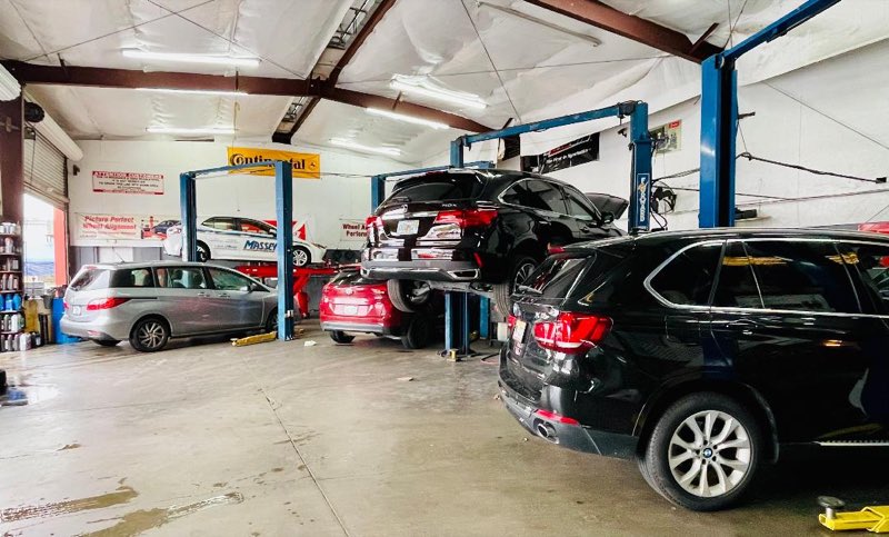 Workshop interior at Ideal Service Center - cars up on the two-post lifts